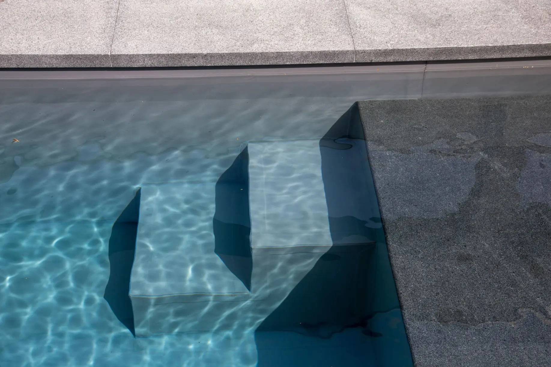 Piscine avec des reflets bleus et marches— Le Petit Baigneur