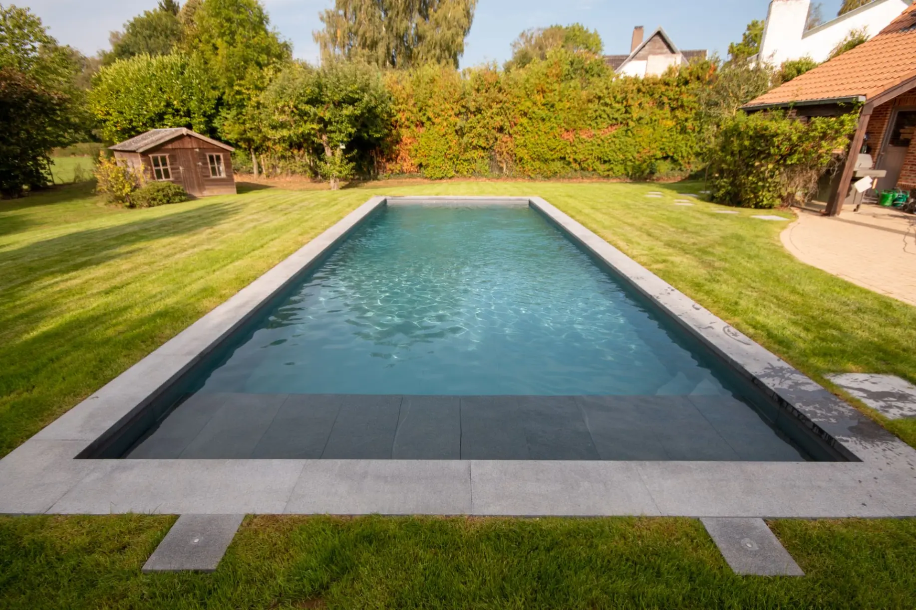 Piscine étroite et longue bordée d’arbres — Le Petit Baigneur