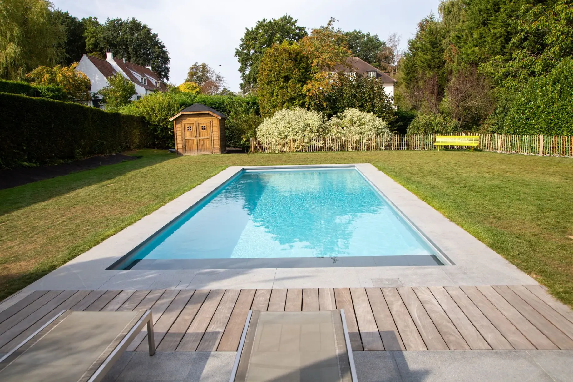 Piscine rectangulaire moderne entourée de haies — Le Petit Baigneur