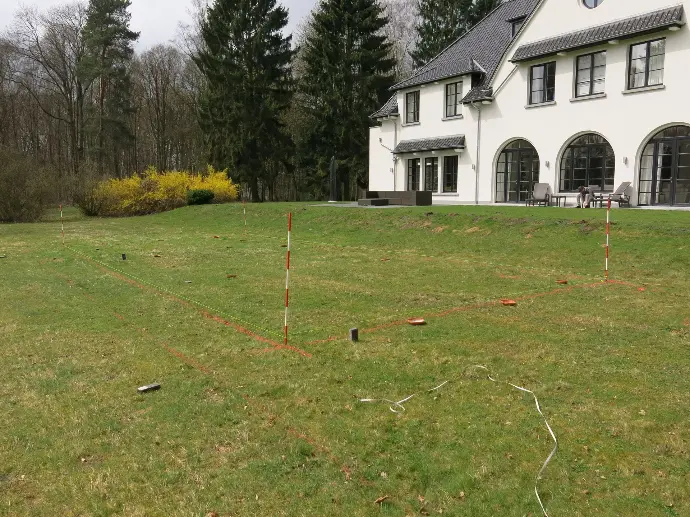 Implantation de piscine dans jardin résidentiel devant maison classique