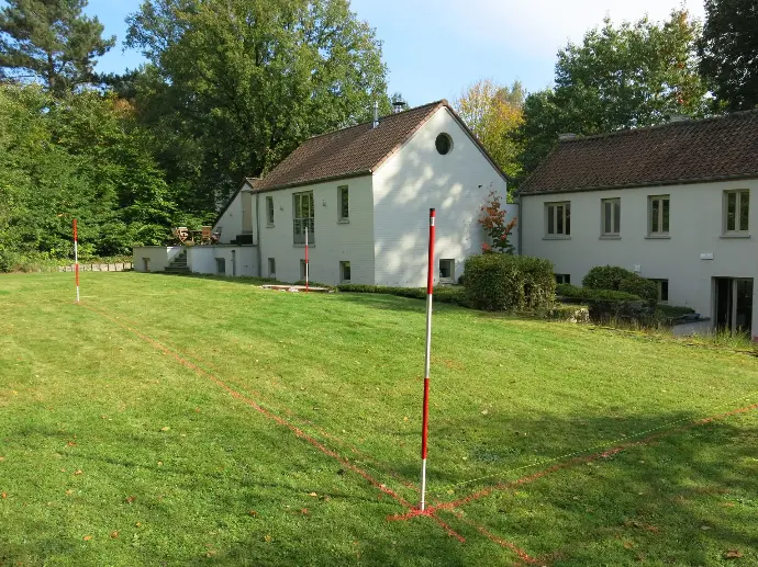 Implantation de piscine sur terrain plat devant une maison blanche – Le Petit Baigneur